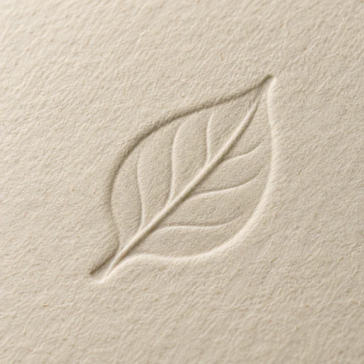 Close view of a leaf-shaped blind emboss on textured ivory paper.
